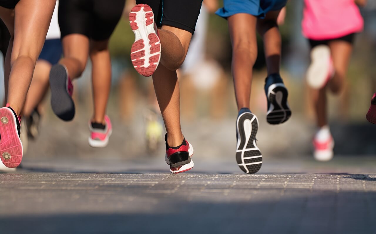 A group, participating in a marathon, their skin tanned.