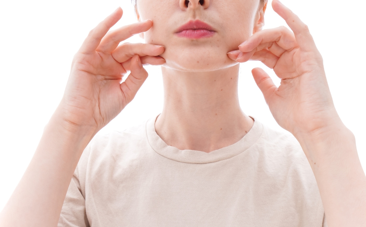 Woman examining excess fat under chin before fat dissolving injections at Millennium Clinic KL