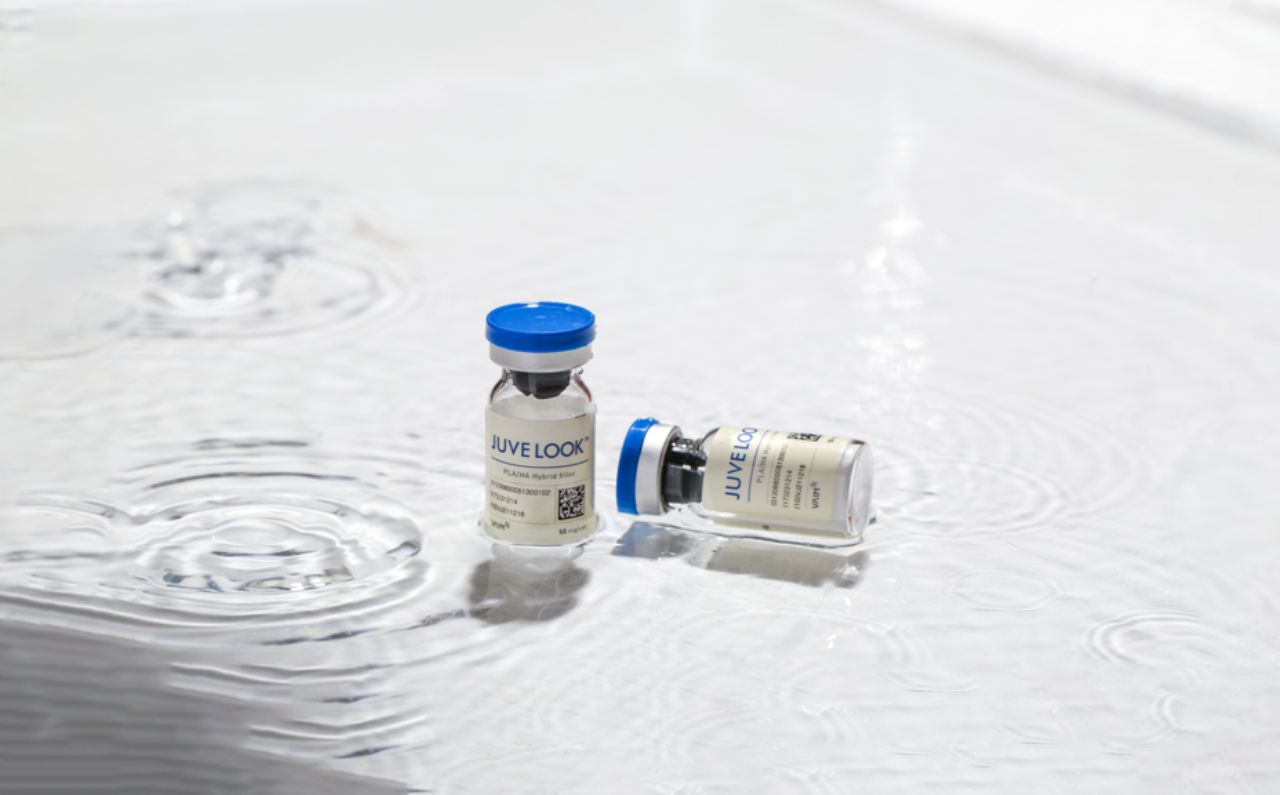 JuveLook bottle placed in a clear pool of water, representing skin hydration and rejuvenation.