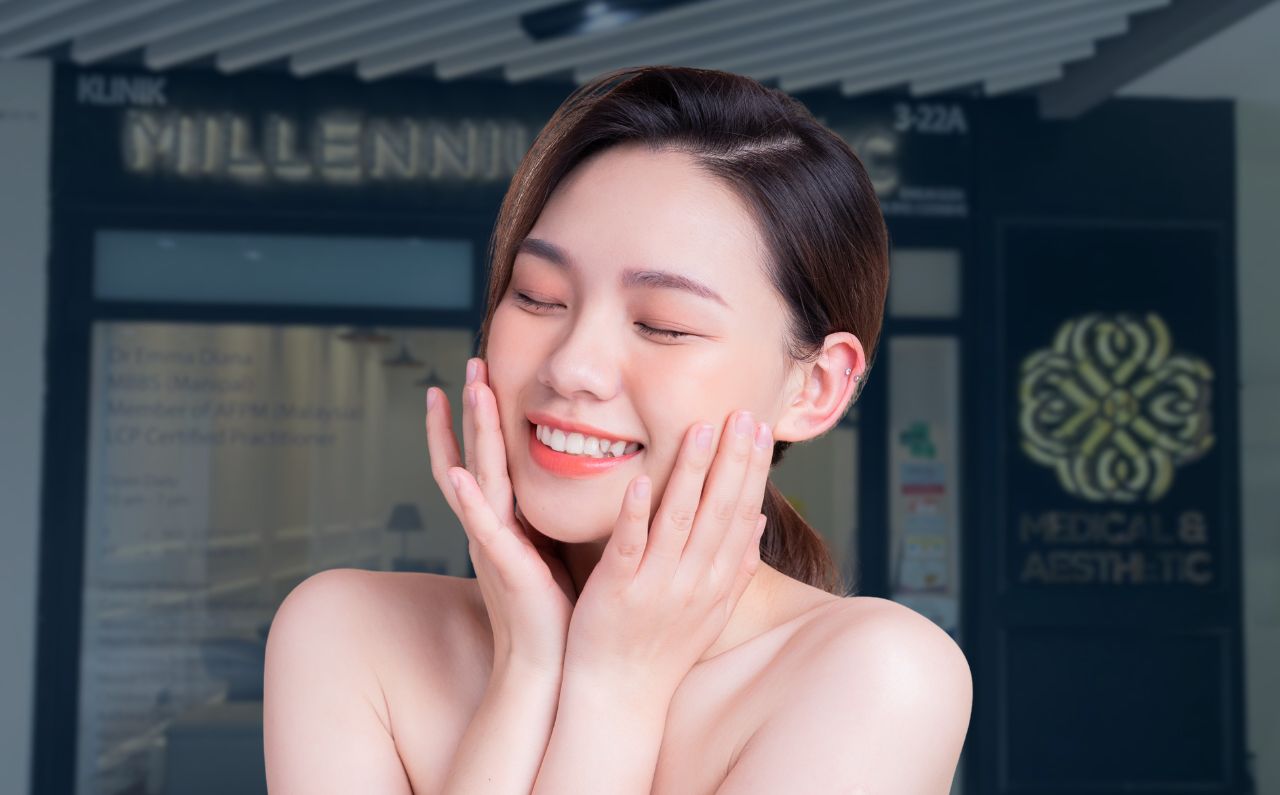 Smiling woman gently touching her skin with Millennium Clinic KL in the background, illustrating expert aesthetic care for smoother, rejuvenated skin.