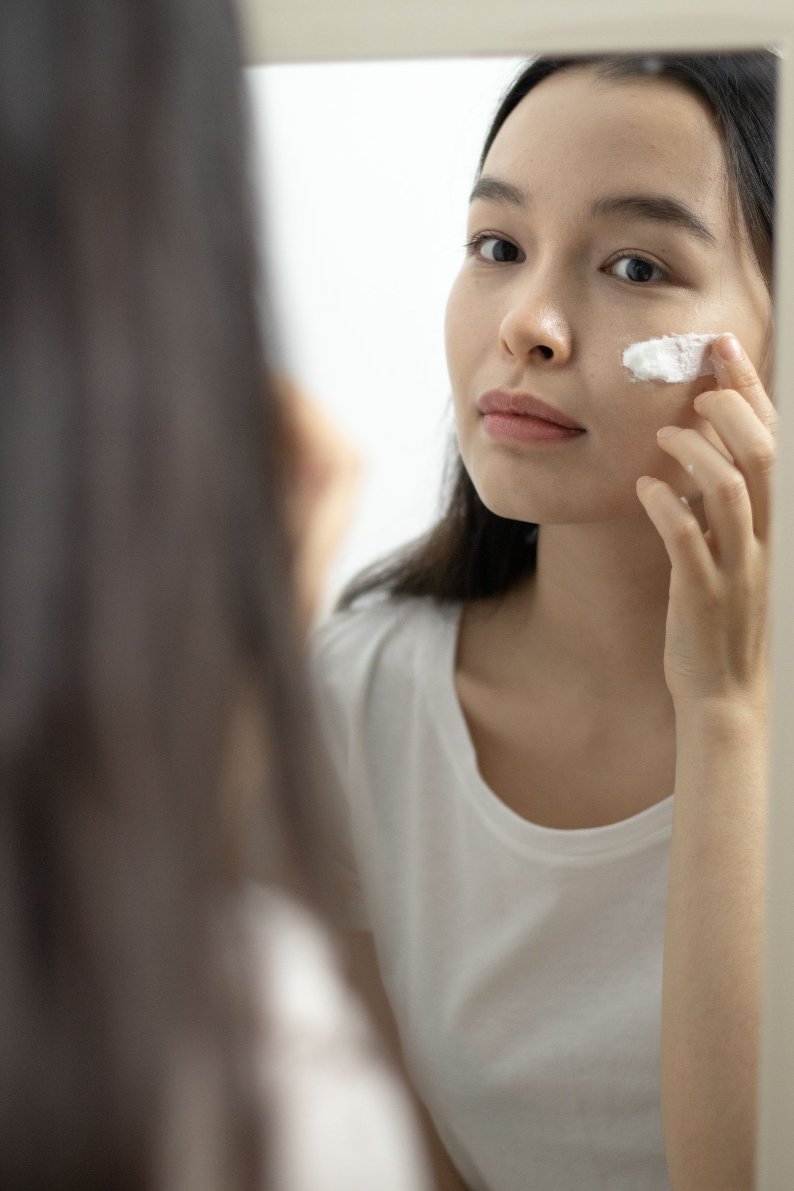 Woman examining and caring for the lower face while looking in a mirror