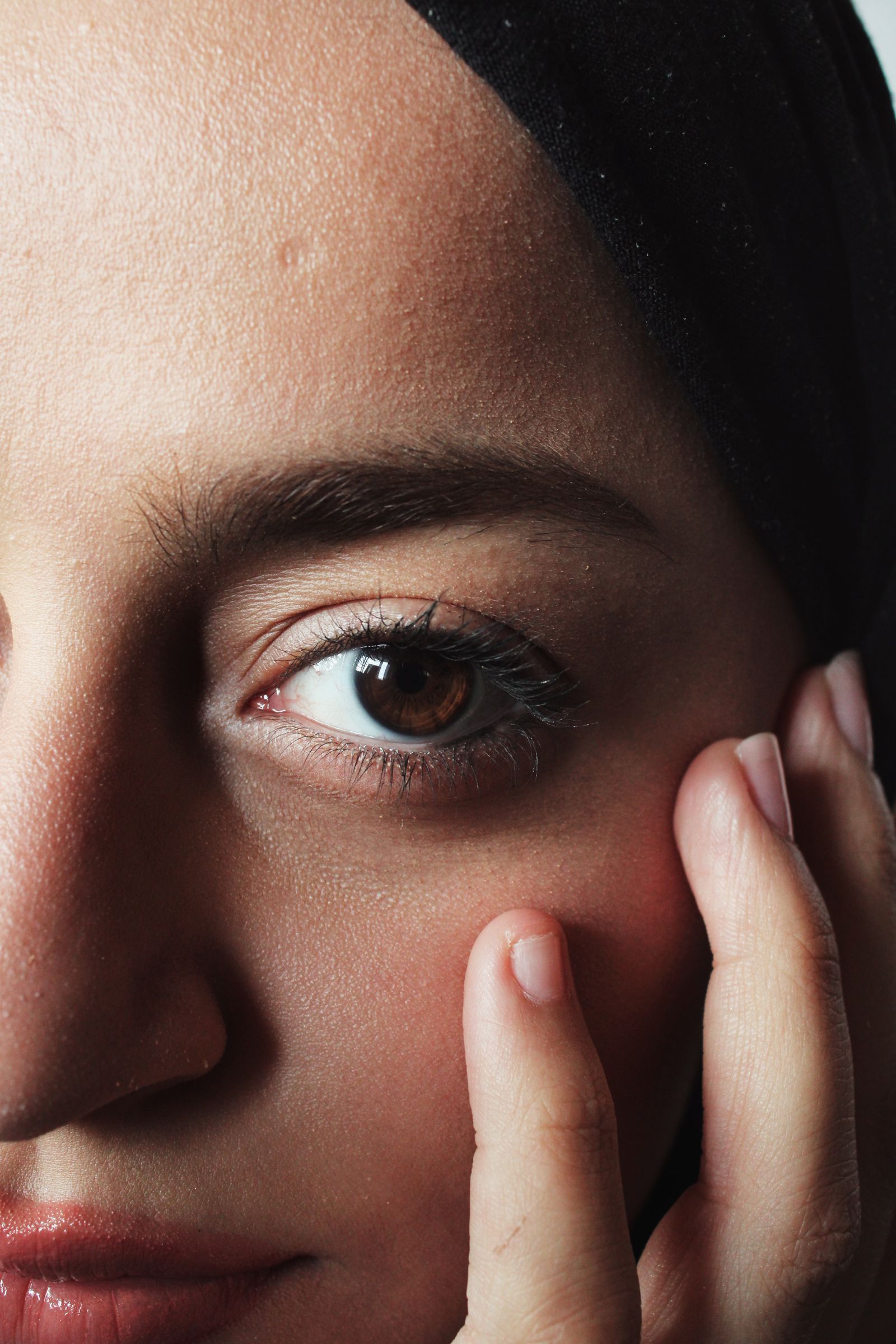 Close-up portrait of a woman touching the cheek and jaw area