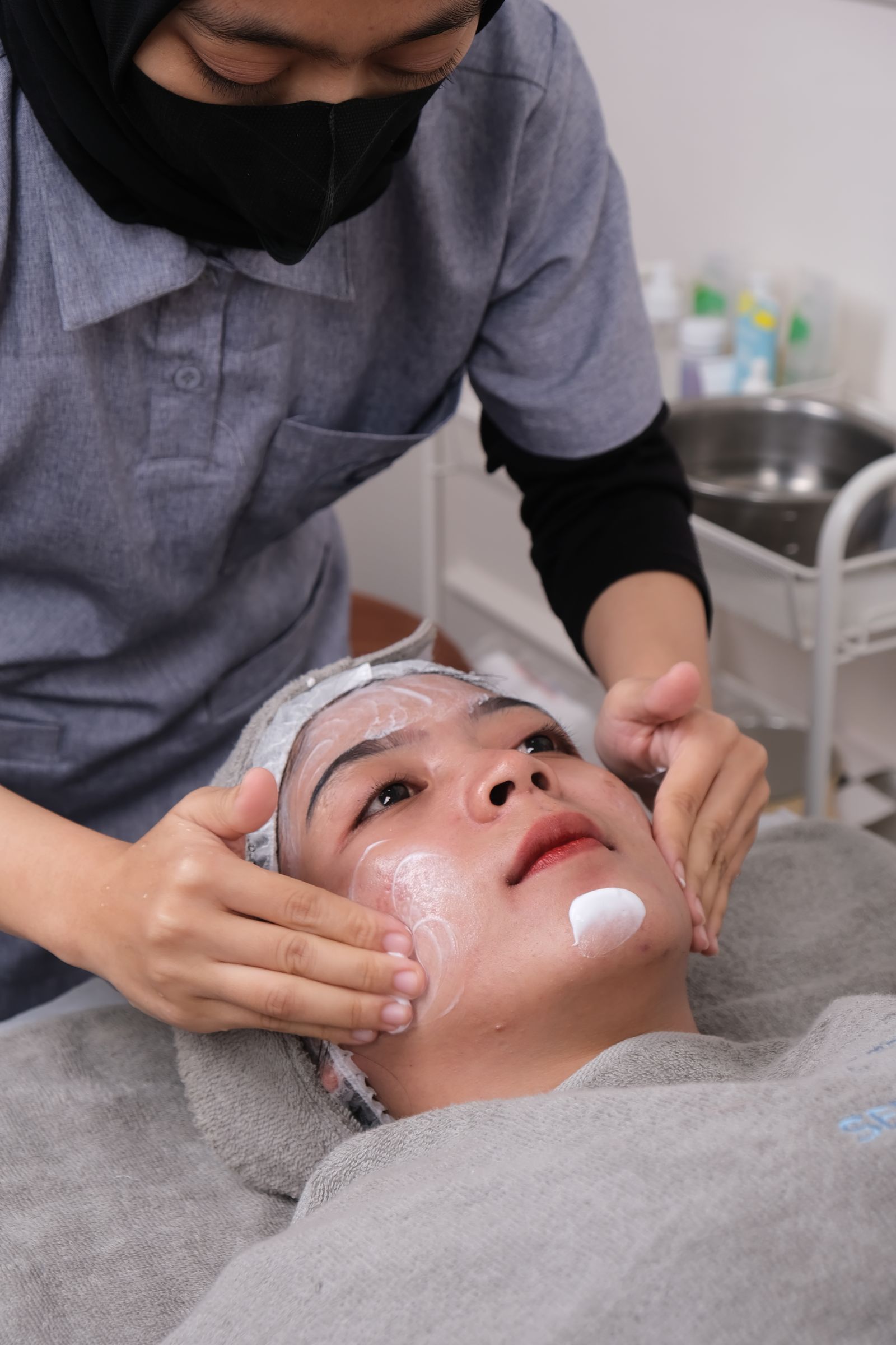 Skincare professional performing a facial treatment in a clinic
