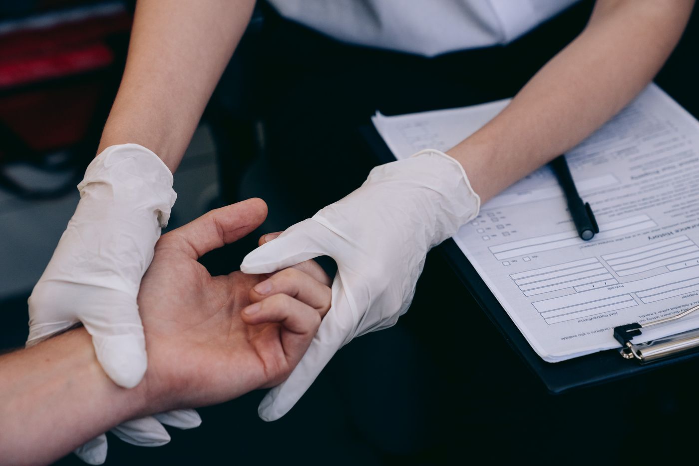Healthcare worker using gloves during examination of a patient's hand