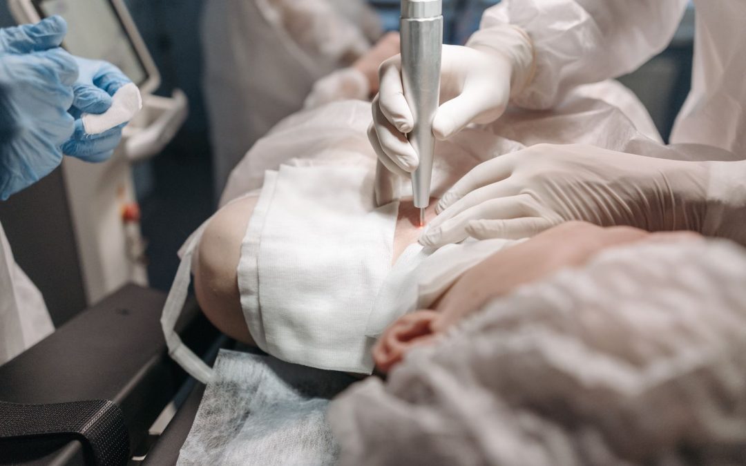 Medical professionals using equipment during a skin procedure